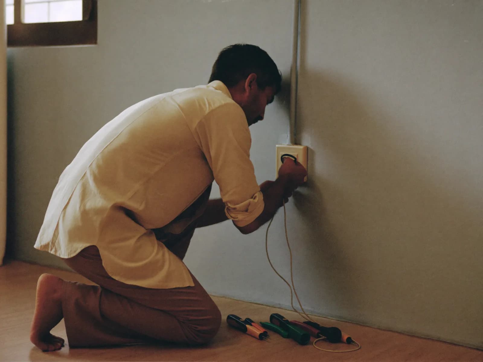 An electrician wiring a switchboard in a home